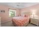 Serene bedroom with peach walls, white furniture, a ceiling fan, and a large window at 5725 Greenwood Ave # 1201, North Port, FL 34287
