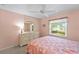 Bright bedroom with peach walls, white dresser, a ceiling fan, and a large window at 5725 Greenwood Ave # 1201, North Port, FL 34287
