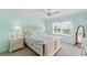 Bedroom featuring mint walls, ceiling fan, bed with decorative quilt and a window with blinds and valance at 5725 Greenwood Ave # 1201, North Port, FL 34287