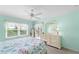 Bedroom with bed, ceiling fan and dresser with mirror, with a screened balcony visible through a sliding glass door at 5725 Greenwood Ave # 1201, North Port, FL 34287