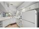 Open concept kitchen with white appliances, tile flooring, breakfast bar, and ample counter space at 5725 Greenwood Ave # 1201, North Port, FL 34287