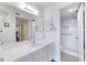 Bathroom vanity with mirror leads to tiled walk-in shower with handrails at 612 Bird Bay S Dr # 311, Venice, FL 34285