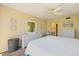 Bright bedroom features ceiling fan, dresser with mirror, and ensuite bath access at 612 Bird Bay S Dr # 311, Venice, FL 34285