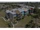 Exterior view of the condo building featuring screened balconies, a well-maintained facade, and lush greenery at 612 Bird Bay S Dr # 311, Venice, FL 34285