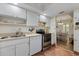 Functional kitchen with white cabinets, stainless steel appliances, and a view into the dining area at 612 Bird Bay S Dr # 311, Venice, FL 34285
