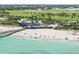 Aerial view of the beach with beachgoers, restaurant, pier, and lush greenery nearby at 616 Guild Dr # 2, Venice, FL 34285