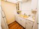 Classic kitchen with white cabinetry, yellow sink, and laminate wood-look flooring at 616 Guild Dr # 2, Venice, FL 34285