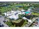 Aerial view of the community clubhouse featuring a pool, ponds, golf course, and tennis courts at 643 Crossfield Cir # 13, Venice, FL 34293