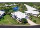 Aerial view of a charming white single-story home with pristine landscaping and a tranquil pond at 643 Crossfield Cir # 13, Venice, FL 34293