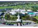 Aerial view of the community clubhouse featuring a pool, ponds, golf course, and tennis courts at 643 Crossfield Cir # 13, Venice, FL 34293