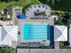 Aerial view of community pool and amenities featuring lounge chairs, tables, and a blue pool at 643 Crossfield Cir # 13, Venice, FL 34293