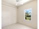 Bedroom with tile floors, ceiling fan, and a window offering views of the community at 643 Crossfield Cir # 13, Venice, FL 34293