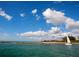Picturesque coastal view with clear waters, sandy beach, and a sailboat, embodying serene waterfront living at 643 Crossfield Cir # 13, Venice, FL 34293
