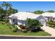 Well-maintained white single-story home with lush landscaping, attached garage, and pristine surroundings at 643 Crossfield Cir # 13, Venice, FL 34293