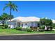 Charming single-story home featuring a white tile roof, lush landscaping, and a vibrant green lawn at 643 Crossfield Cir # 13, Venice, FL 34293
