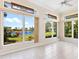 Spacious living room featuring tile floors and big windows framing a picturesque view of the lush landscaping at 643 Crossfield Cir # 13, Venice, FL 34293