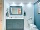 Updated bathroom features a vanity with a blue cabinet, a toilet, a decorative mirror, and new fixtures at 839 Wexford Blvd # 839, Venice, FL 34293