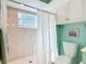 Bright bathroom featuring a tiled shower with glass door, a white toilet, and ample storage cabinets at 839 Wexford Blvd # 839, Venice, FL 34293