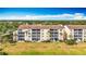 Exterior view showcasing condo building with private patios overlooking manicured lawns and palm trees at 839 Wexford Blvd # 839, Venice, FL 34293