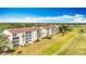 Aerial shot of condo building in a golf course community with well-manicured lawns and palm trees at 839 Wexford Blvd # 839, Venice, FL 34293