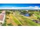 Aerial view of community golf course featuring tree lined green and water features at 839 Wexford Blvd # 839, Venice, FL 34293