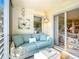 Comfortable sitting room with light blue couch and ottoman next to sliding glass doors with a peek into the bedroom at 839 Wexford Blvd # 839, Venice, FL 34293