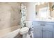 Bright bathroom with marble-like tiled shower and light blue vanity that adds a touch of elegance to this space at 8432 Culebra Ave, North Port, FL 34287