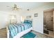 Bright bedroom with patterned bedding, a ceiling fan, and access to an en-suite bathroom at 8432 Culebra Ave, North Port, FL 34287