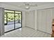 Bright bedroom featuring a ceiling fan, access to the screened in patio, and built in closets at 846 Senda Plata # 26, Venice, FL 34293