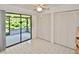 Bright bedroom featuring a ceiling fan, access to the screened in patio, and built in closets at 846 Senda Plata # 26, Venice, FL 34293