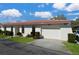Charming single-story villa with a red tile roof, tidy landscaping, and an attached one car garage under a bright blue sky at 846 Senda Plata # 26, Venice, FL 34293