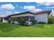 Back exterior view of the home with a well manicured lawn at 846 Senda Plata # 26, Venice, FL 34293