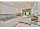 Well-lit kitchen boasts white cabinetry, a ceiling fan, and a window overlooking the backyard at 846 Senda Plata # 26, Venice, FL 34293