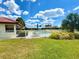 Community pool with white fence, lounge chairs, umbrella, landscaping, and nearby white villa buildings with red tile roofs at 846 Senda Plata # 26, Venice, FL 34293