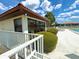 Community pool area with white fence, lounge chair and beautifully manicured landscaping at 846 Senda Plata # 26, Venice, FL 34293