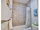 Tiled bathtub with shower and glass shelves plus a decorative shower curtain at 863 Southland Rd, Venice, FL 34293