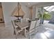 Dining room with tile floors, large wooden table, chairs and sliding doors leading to patio and pool at 863 Southland Rd, Venice, FL 34293