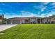 Beautiful single-story home featuring a three-car garage, green lawn, and well-maintained landscaping under a cloudy blue sky at 863 Southland Rd, Venice, FL 34293