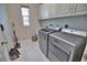 Laundry room featuring a washer and dryer with white cabinets and tile flooring at 863 Southland Rd, Venice, FL 34293
