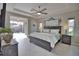 Bright main bedroom with king bed, en-suite bathroom, tray ceilings, slider to screened in pool and ceiling fan at 863 Southland Rd, Venice, FL 34293