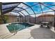 Relaxing pool in a screened enclosure with dining table and chairs for outdoor enjoyment in a sunny backyard at 863 Southland Rd, Venice, FL 34293