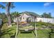 A nicely maintained yard with a wood swing set, partially fenced perimeter and lush lawn at 915 Citrus Rd, Venice, FL 34293