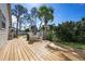 Inviting backyard with a wood deck, white outdoor furniture, and lush landscaping at 915 Citrus Rd, Venice, FL 34293