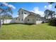 Well maintained backyard and lawn showing rear of the house with white fencing and mature trees at 915 Citrus Rd, Venice, FL 34293
