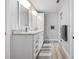 Bright bathroom with a double sink vanity, granite countertop, and wood-look tile floor at 915 Citrus Rd, Venice, FL 34293