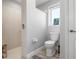 Bright bathroom featuring a toilet and a tiled shower, offering a clean and modern space at 915 Citrus Rd, Venice, FL 34293