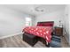 A cozy bedroom featuring wood-look flooring, a ceiling fan, and a comfortable bed with a colorful dog-themed cover at 915 Citrus Rd, Venice, FL 34293