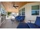 Inviting covered porch featuring tongue and groove ceiling, ceiling fan, outdoor furniture, and concrete tile at 915 Citrus Rd, Venice, FL 34293