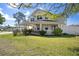 Charming two-story home with a covered front porch, well-manicured lawn, and lush landscaping at 915 Citrus Rd, Venice, FL 34293