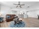 Open-concept living room with wood floors, a ceiling fan and a view of the kitchen bar at 915 Citrus Rd, Venice, FL 34293